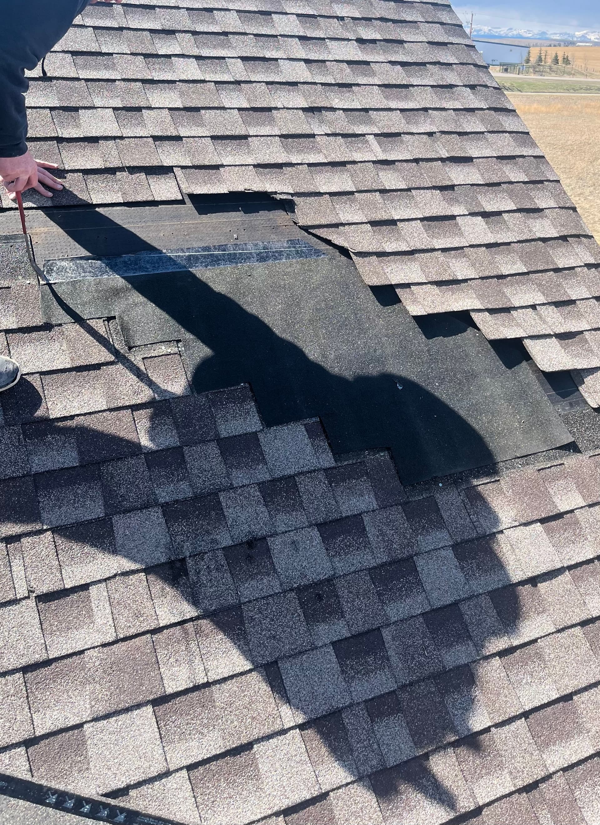 Missing shingles on a Calgary roof after wind damage
